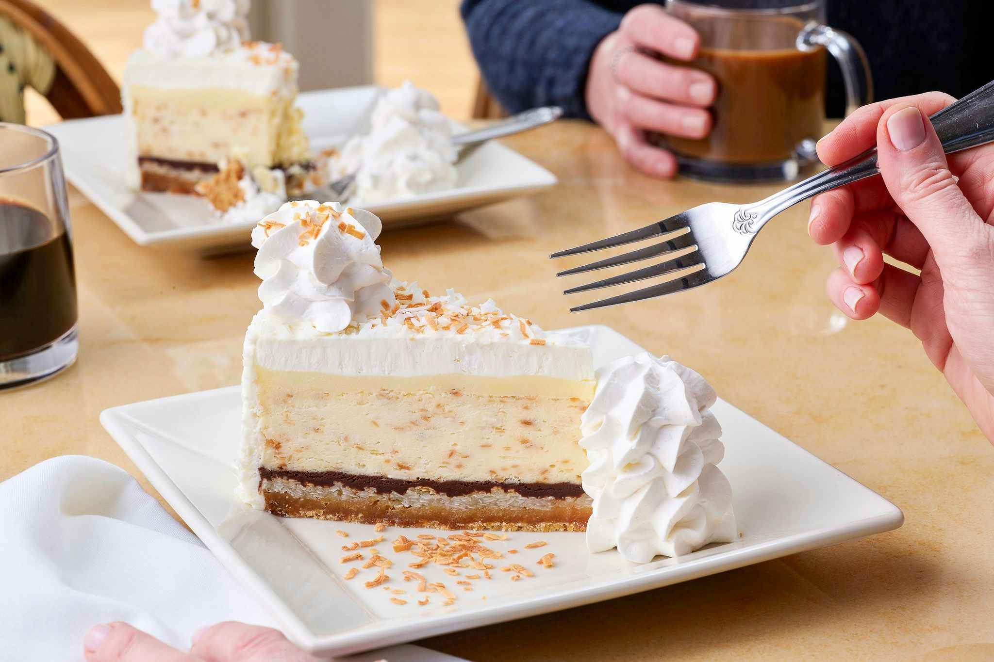 Someone about to use a fork to cut into a slice of cheesecake at The Cheesecake Factory