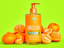 a bottle of hand wash next to tangerines 