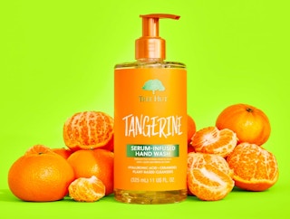 a bottle of hand wash next to tangerines 
