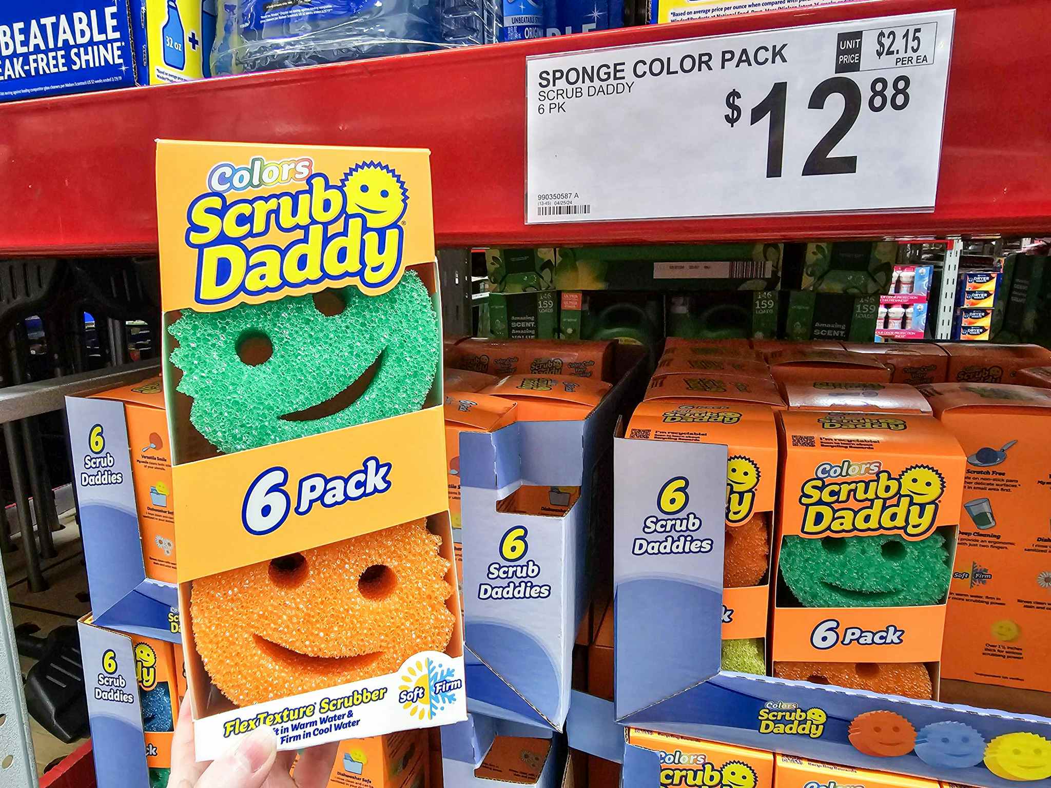 person holding a pack of scrub daddy sponges by a price tag for $12.98
