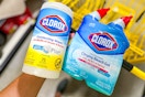 hand holding clorox products above yellow shopping cart