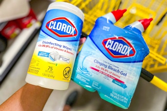 hand holding clorox products above yellow shopping cart