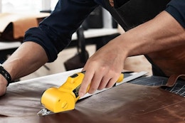 person using cardboard cutter on fabric