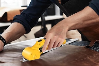 person using cardboard cutter on fabric