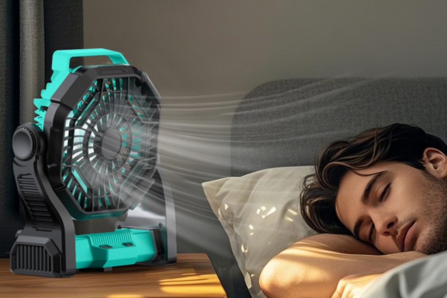 a man sleeping next to a fan
