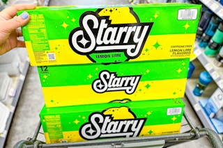 hand holding 12-pack soda steady stacked on top of two packs in shopping cart