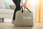a person holding an air mattress in a bag