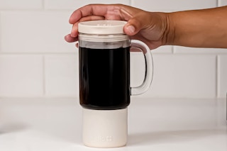 Lifestyle image of Ello Glass Tumbler — close up of someone putting on the lid