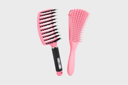 two hair brushes on a grey background
