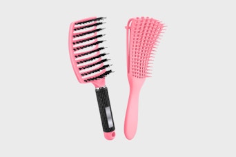 two hair brushes on a grey background