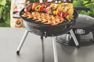 lifestyle image of a portable grill with food cooking