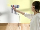a person using a paint sprayer on a wall 