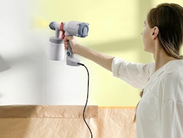 a person using a paint sprayer on a wall 