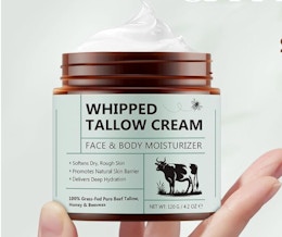 a hand holding a jar of cream