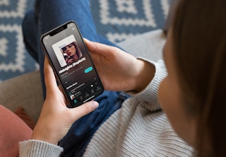 Woman looking at Amazon Music free on her phone, ready to shuffle Midnights by Taylor Swift