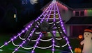 a giant faux spider in a web with purple lights