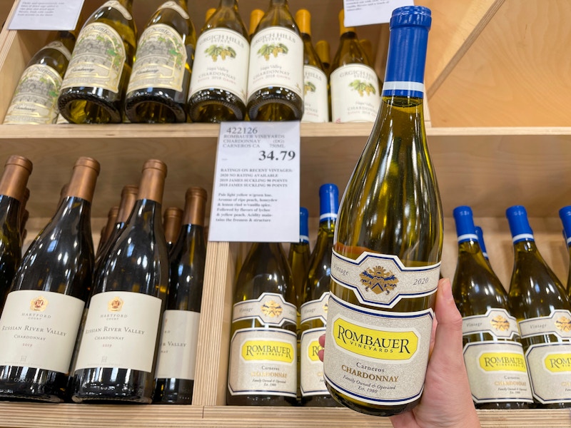 A bottle of wine held next to a price tag at Costco