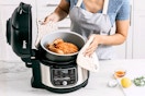Lifestyle image of the Ninja Foodi 10-in-1 6.5 qt Pressure Cooker being used to cook a chicken