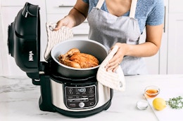 Lifestyle image of the Ninja Foodi 10-in-1 6.5 qt Pressure Cooker being used to cook a chicken