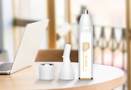 a nose and hair trimmer on a table with a laptop