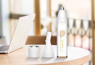 a nose and hair trimmer on a table with a laptop