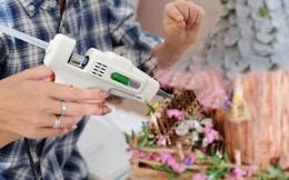 a person using a hot glue gun
