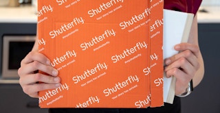 person taking shutterfly photo book from package