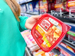 woman holding a tub of hillshire farm deli meat in walmart aisle