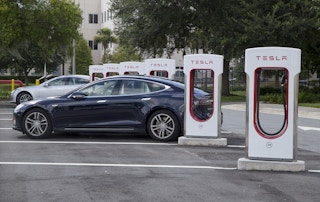 Two Tesla cars parked at a Tesla charging lot