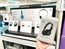 hand holding beats 4 wireless headphones in front of a target shelf