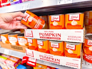 hand holding a can of libbys pumpkin puree on walmart shelf
