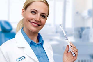 person holding oral-b healthy clean toothbrush