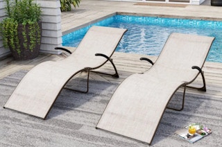 two lounge chairs outside by a pool