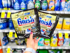 hand holding two finish dishwasher tabs eleven count packages in cvs