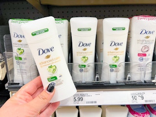 Hand holding Dove Deodorant stick in front of a shelf with other Dove deodorants