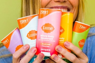 smiling person holding 5 sticks of lume deodorant
