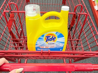 A 128oz container of Tide Simply Clean & Fresh detergent in a Staples shopping cart.