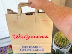 hand holding walgreens delivery bag