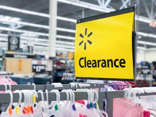 A Walmart clearance sign above a rack of kids clothes