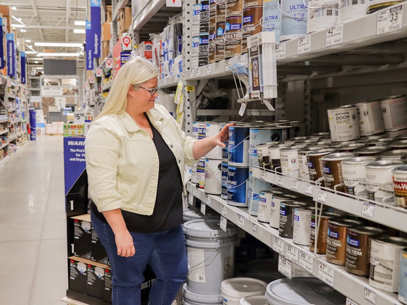 a person looking at paint at lowes