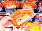 hand holding hillshire farm smoked sausage in walmart aisle