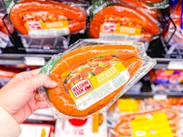 hand holding hillshire farm smoked sausage in walmart aisle