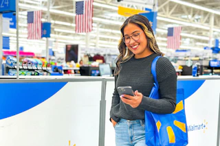 woman shopping at walmart on her phone with USA flags in the background