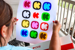 person holding photo poster with krazy coupon lady logos