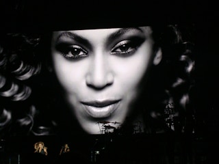 Beyonce tour with a large screen showing her face in black and white