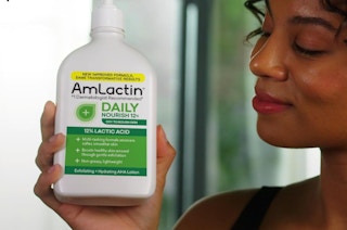 a hand holding a bottle of lotion