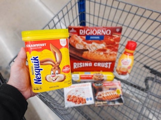 Nesquik Strawberry Mix held over Walmart shopping cart. The cart is full of Digiorno, Coffee Mate, Lean Cuisine, Stouffers, and Nestle ...