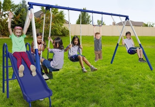 blue metal swing set outside with kids playing on it
