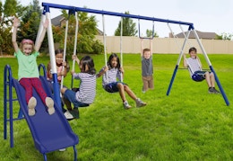 blue metal swing set outside with kids playing on it