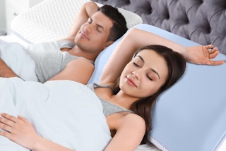 a woman and man sleeping on memory foam pillows